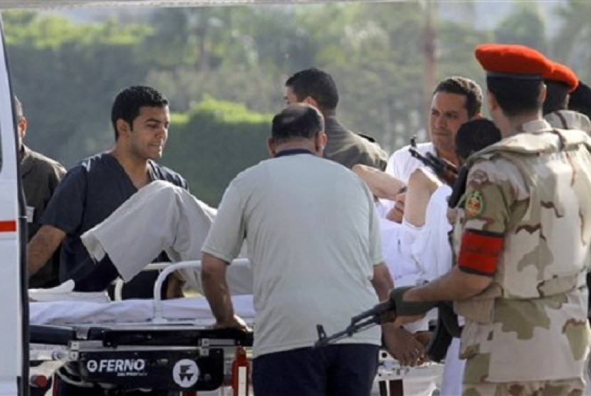 Egyptian medics and military policemen escort former Egyptian president Hosni Mubarak into an ambulance after after he was flown by a helicopter ambulance to the Maadi Military Hospital from Torah prison in, Cairo, Egypt, Thursday, Aug. 22, 2013. 