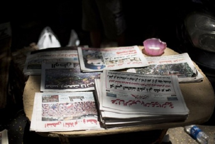 Egyptian newspapers are seen in a street kiosk near Cairo University in Cairo, Thursday, July 4, 2013. The chief justice of Egypt's Supreme Constitutional Court was sworn in Thursday as the nation's interim president, taking over hours after the military o