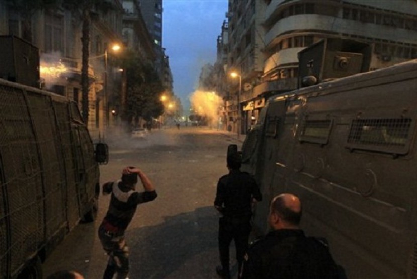 Egyptian security forces try to disperse protesters demonstrating against the government on a street off Cairo's Tahrir Square on Sunday, Dec. 1, 2013. 