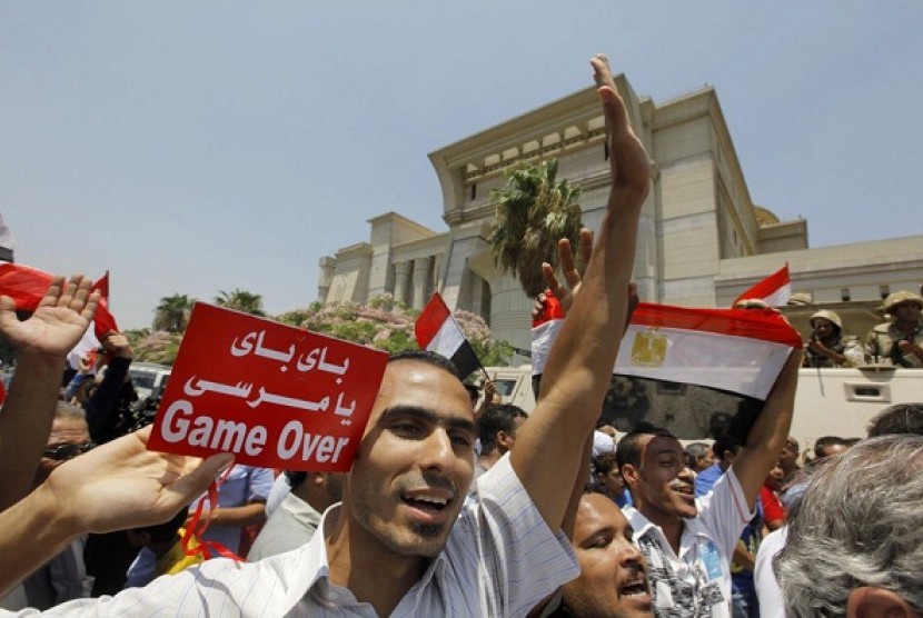 Egyptians celebrate in front of the constitutional court after Egypt's chief justice Adly Mansour was sworn in as the nation's interim president Thursday, July 4, 2013. Arabic reads, 