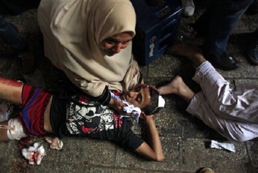 Egyptians lay on the ground after being injured during clashes between security forces and supporters of Egypt's ousted President Mohammed Morsi in Ramses Square, near the Al-Fath mosque, in Cairo, Egypt, Friday, Aug. 16, 2013. 