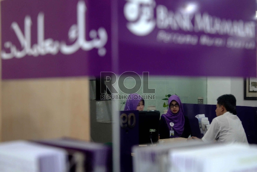Ekonomi Syariah Solusi Krisis Global: Karyawan melayani nasabah berada di kantor Bank Muamalat, Jakarta, Kamis (9/4).