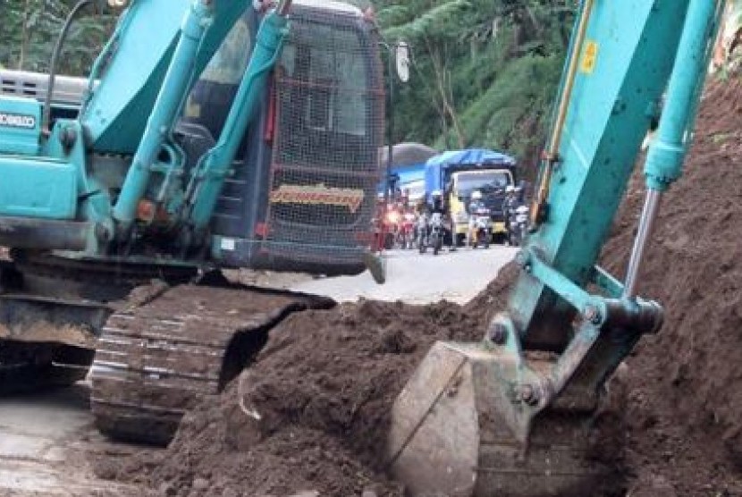 Ekskavator menggali material longsoran di jalan Trenggalek-Ponorogo.