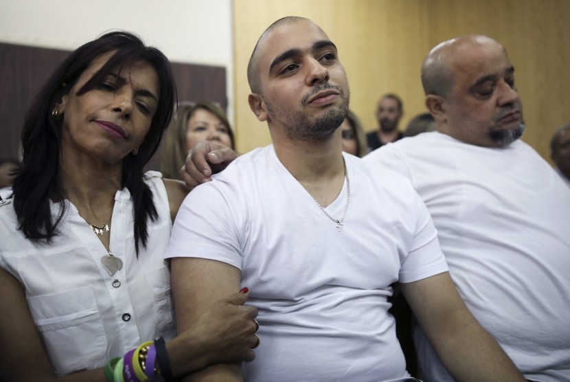 Elor Azaria (tengah) diapit kedua orangtuanya di sidang pengadilan di Tel Aviv, (30/7). Ia divonis bersalah setelah membunuh warga Palestina yang terluka di Hebron tahun 2016.