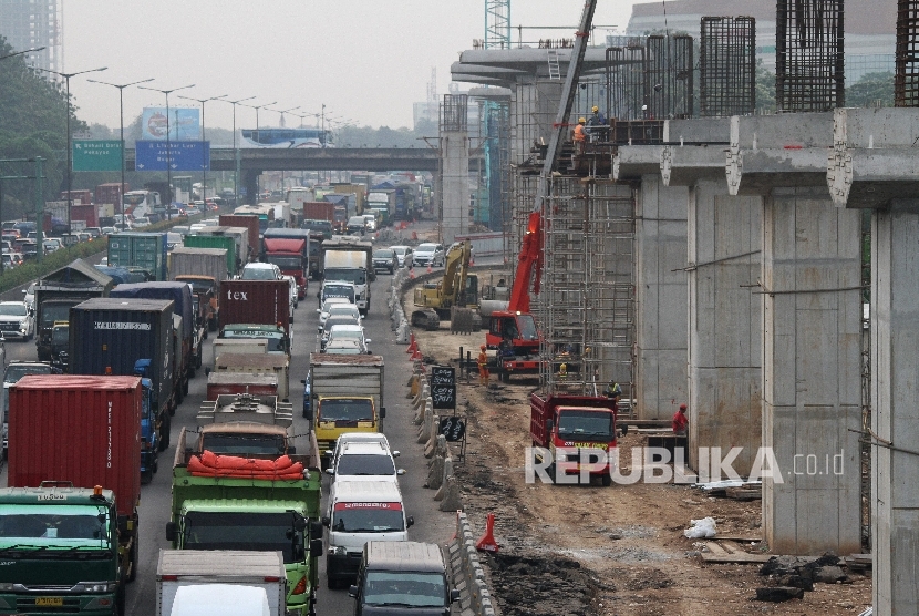 Pengendara melintas di samping area pembangunan jalur kereta api ringan (LRT) dan jalan tol layang Jakarta-Cikampek II, di ruas jalan Tol Jakarta-Cikampek, di Bekasi, Jawa Barat (ilustrasi).