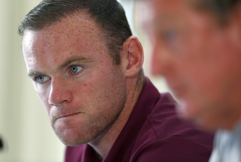 England captain Wayne Rooney (L) listens to manager Roy Hodgson during a news conference at their team hotel in Watford, north of London, September 2, 2014. England will play Norway in a friendly soccer match in London on Wednesday.