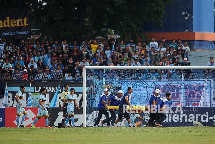 enjaga gawang Persela Lamongan Choirul Huda ditandu petugas kesehatan ketika bertanding melawan Semen Padang dalam lanjutan Gojek Traveloka Liga 1 di Stadion Surajaya Lamongan, Jawa Timur, Minggu (15/10).