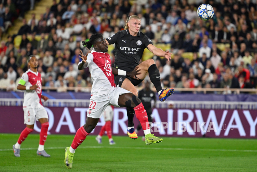 Erling Haaland dari Manchester City, kanan, mencetak gol pembuka meskipun diadang oleh Mohammed Salisu dari Monaco dalam pertandingan pembuka Liga Champions antara Monaco dan Manchester City di Stadion Louis II, Monaco, Kamis, 2 Oktober 2025.