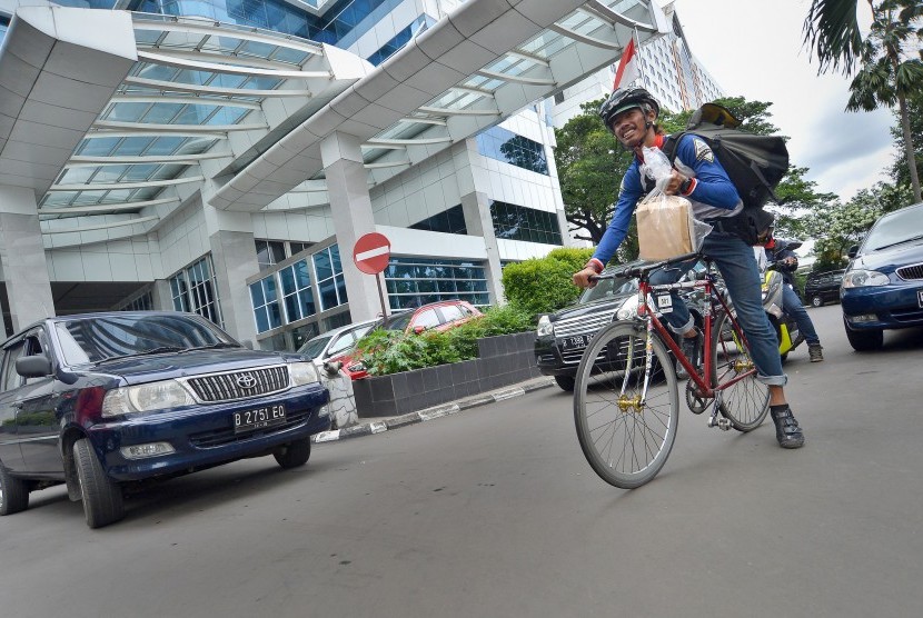 Petugas jasa kurir bersepeda mengayuh sepedanya saat mengantar paket di kawasan Senayan, Jakarta (ilustrasi)