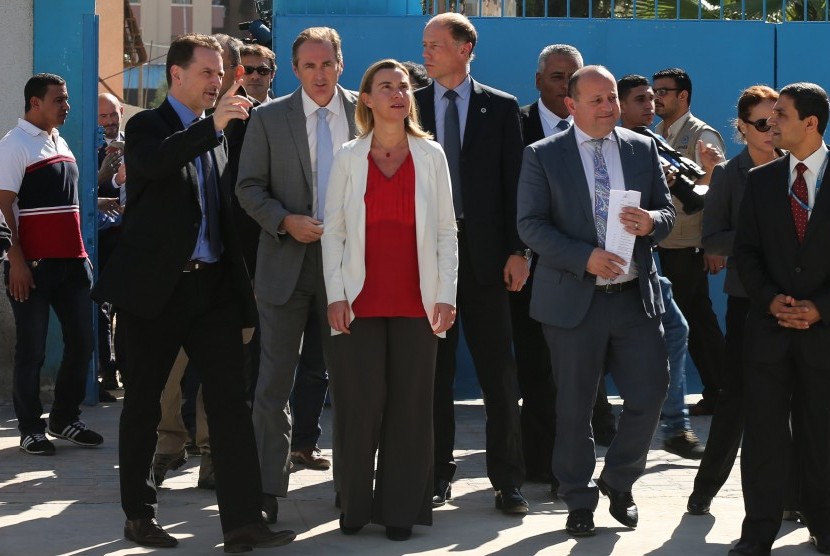 European Union foreign policy chief Federica Mogherini (C) looks on as she visits a UN-run school sheltering Palestinians, whose houses were destroyed during the most recent conflict between Israel and Hamas, in Gaza City November 8, 2014.