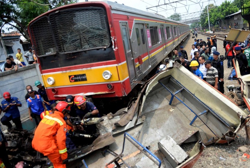 Evakuasi Bangkai Bus Metromini. Petugas melakukan evakuasi bangkai Bus Metromini pascatabrakan dengan KRL di Kawasan Stasiun Angke, Jakarta Barat, Ahad (6/12). 