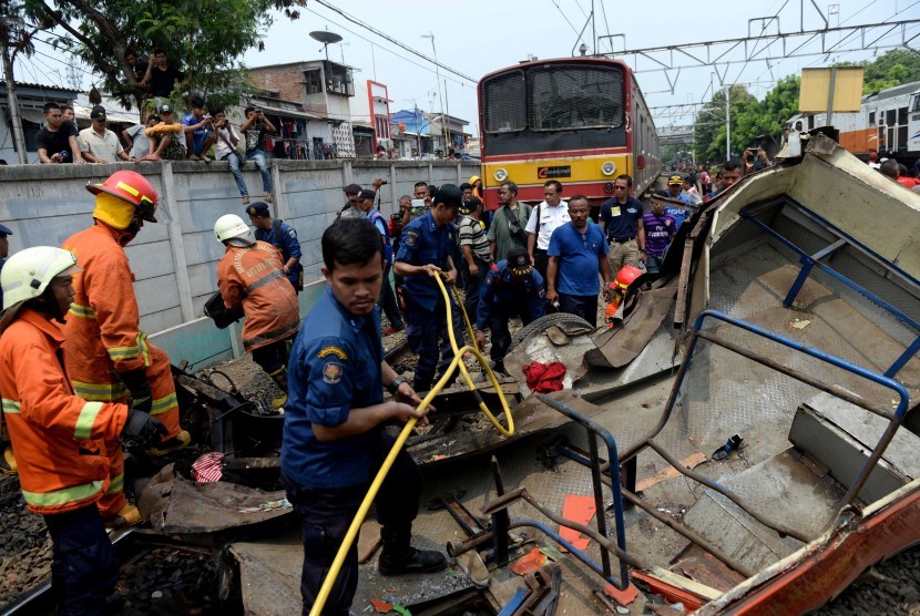 Evakuasi Bangkai Bus Metromini. Petugas melakukan evakuasi bangkai Bus Metromini pascatabrakan dengan KRL di Kawasan Stasiun Angke, Jakarta Barat, Ahad (6/12).