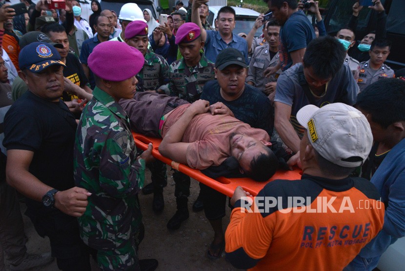 Evakuasi Bolaang Mangondow. Petugas menggotong salah seorang penambang yang selamat dari lokasi Pertambangan Emas Tanpa Izin (PETI) Desa Bakan, Kecamatan Lolayan, Kabupaten Bolaang Mongondouw, Sulawesi Utara, Rabu (27/2/2019).