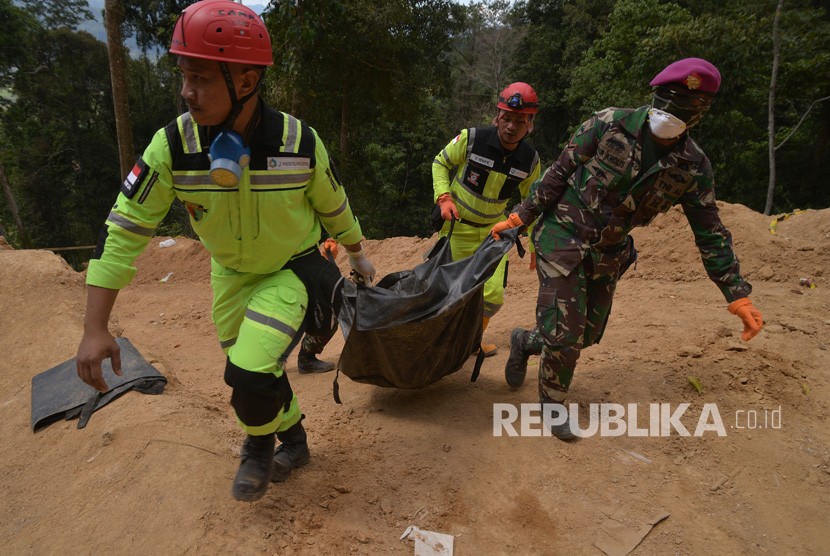 Evakuasi Korban. Tim SAR gabungan mengangkat kantong mayat untuk dibawa ke unit DVI RSUD Kotamobagu, di pertambangan emas tanpa izin (PETI) desa Bakan, Kabupaten Bolaang Mongondow, Sulawesi Utara, Selasa (5/3/2019).