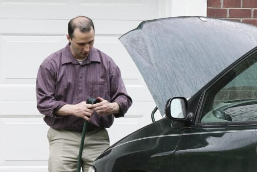 Everett Dutschke works on his mini-van in his driveway in Tupelo Mississippi on April 26, 2013.