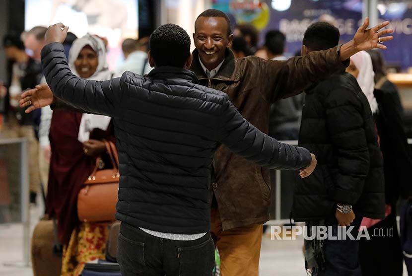 Faisal Etal (C, in brown coat), a Somali national who was delayed entry to the U.S. because of the recent travel ban, is greeted by his brother Adan Etal at Washington Dulles International Airport in Chantilly, Virginia, U.S. February 6, 2017.  