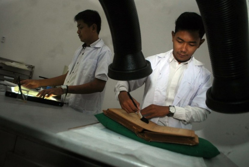 Fajar Wijianarko dan Heru Santoso dari bagian Koleksi, Koservasi dan Restorasi Museum Sonobudyo melakukan pembersihan naskah kuno era dan tulisan majalah tahun 1920 koleksi Museum Sonobudoyo di Gedung Unit II Museum Sonobudoyo, Jalan Wijilan, Yogyakarta, Rabu (30/1). 