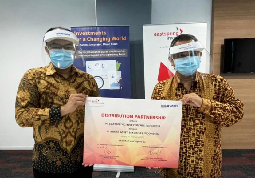 Fajrin Noor Hermansyah, Deputy Director Wealth Management PT Mirae Asset Sekuritas Indonesia (kiri) bersama Ari Pitojo Direktur PT Eastspring Investments Indonesia seusai menandatangani kerja sama distribusi di Jakarta, Rabu (17/2).