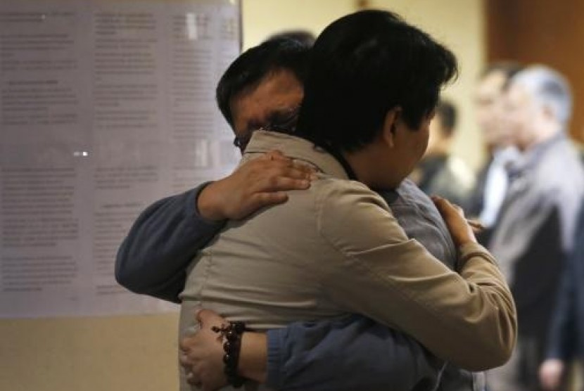 Family members of a passenger onboard the missing Malaysian Airlines flight MH370 hug each other as they wait for news about the missing plane at a hotel in Beijing March 20, 2014.