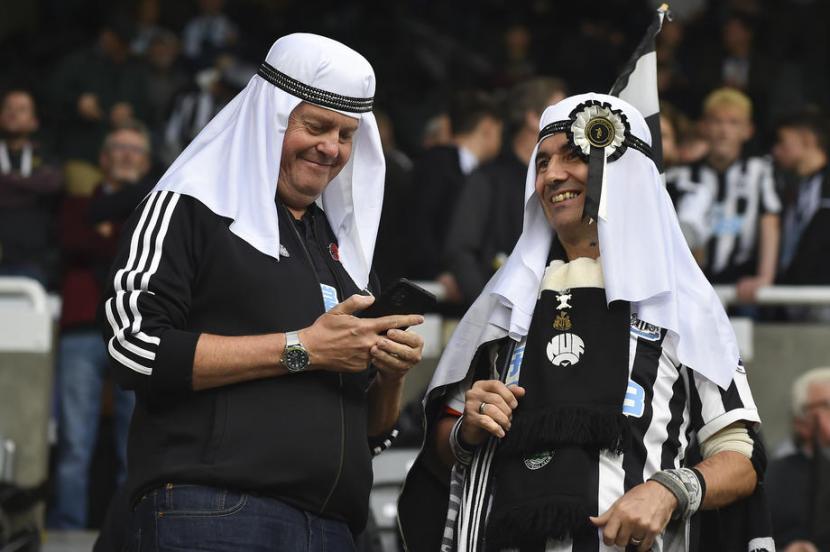 Fan Newcastle United mengenakan tutup kepala tradisional Timur Tengah.
