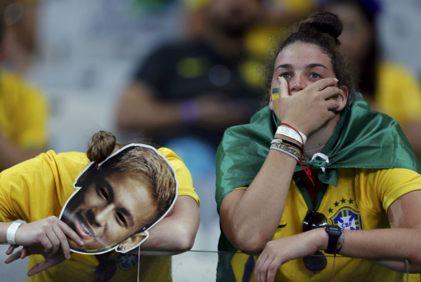 Fans Brasil tampak kecewa setelah menyaksikan timnas Brasil kalah 1-7 dari Jerman di laga semifinal Piala Dunia 2014 di Stadion Mineirao, Belo Horizonte, Selasa (8/7/2014). Penggemar berat sepakbola bisa mengalami stres dengan level yang bisa membahayakan kesehatannya. 