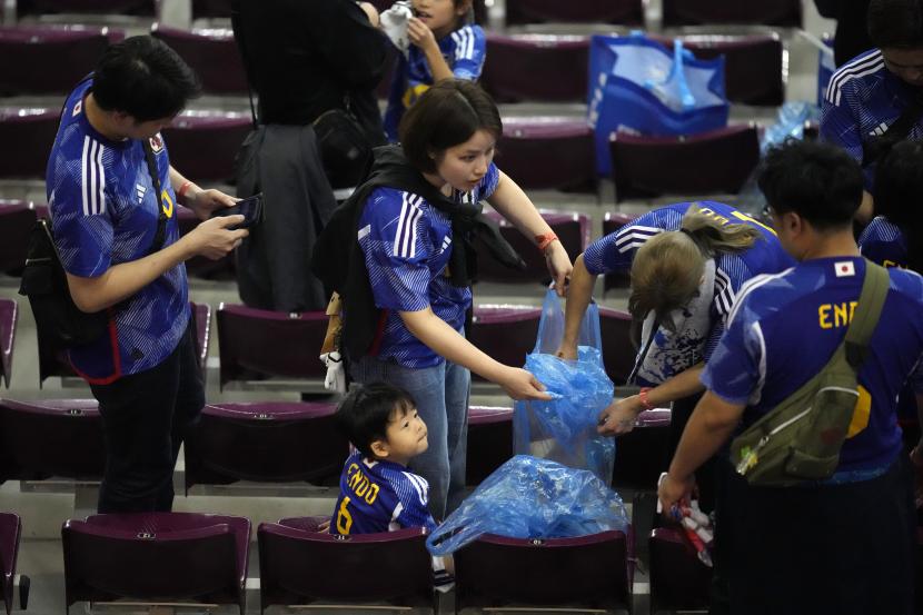 Fans Jepang mengumpulkan sampah setelah pertandingan sepak bola grup E Piala Dunia 2022 