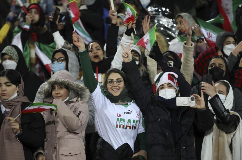 Fans wanita Iran merayakan kualifikasi untuk kualifikasi Piala Dunia 2022, setelah tim sepak bola nasional mereka mengalahkan Irak, di stadion Azadi di Teheran, Iran, Kamis, 27 Januari 2022. Pihak berwenang Iran mengizinkan wanita untuk menonton pertandingan sepak bola di stadion sebagai garis keras telah lama menentang keputusan pemerintah. Iran menjadi tim pertama dari Asia yang lolos ke Piala Dunia tahun ini di Qatar dengan kemenangan 1-0 atas Irak. 