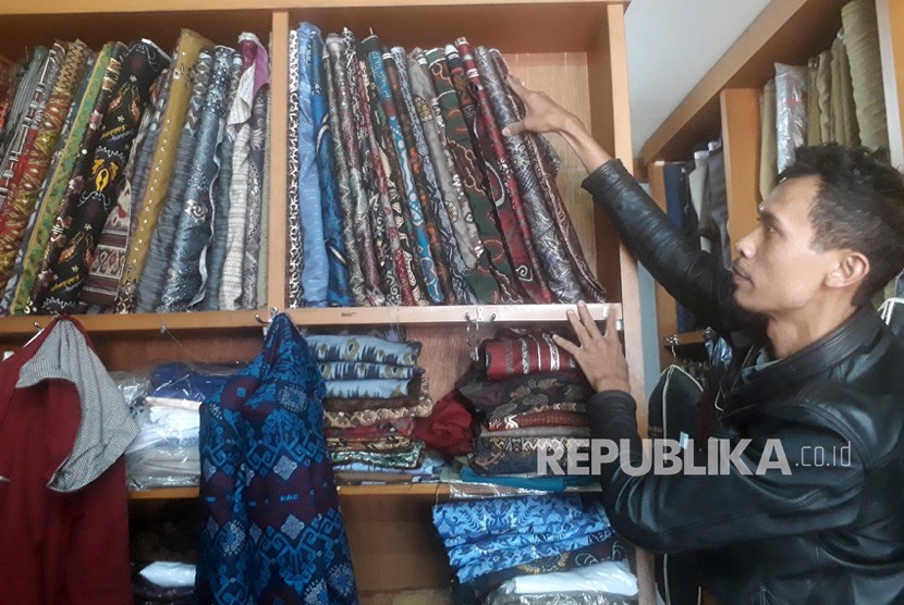 Farid Husein, salah seorang pekerja Sinar Mukti Tailor tengah membereskan  kain batik yang akan digunakan sebagai bahan dasar menjahit pakaian batik,  Kamis (3/10).