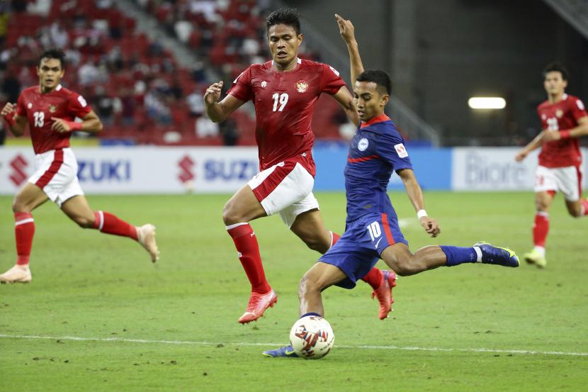 Faris Ramli dari Singapura, depan, melakukan tembakan ke gawang saat Fachruddin Aryanto dari Indonesia terlihat pada pertandingan leg kedua semifinal Piala Suzuki AFF 2020 antara Indonesia dan Singapura di Singapura, Sabtu 25 Desember 2021.