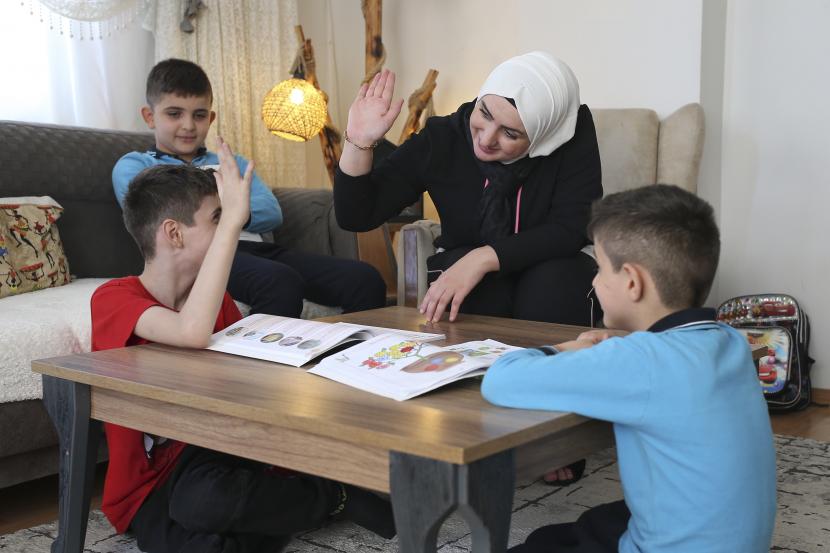 Fatima Alzahra Shon, 32, seorang pengungsi Suriah, mengajar anak-anaknya setelah wawancara dengan The Associated Press di Istanbul, Jumat, 17 September 2021.