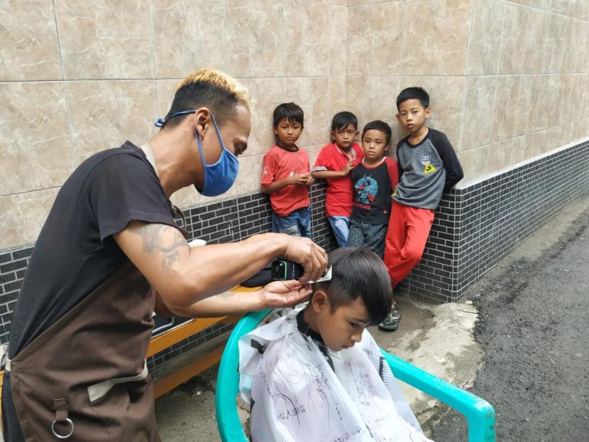 Faul Saepulloh (43) menyediakan jasa cukur gratis di halaman Masjid Bani Mustari, Kampung Lengo, Kelurahan Bantarsari, Kecamatan Bungursari, Kota Tasikmalaya, Jumat (16/10). 