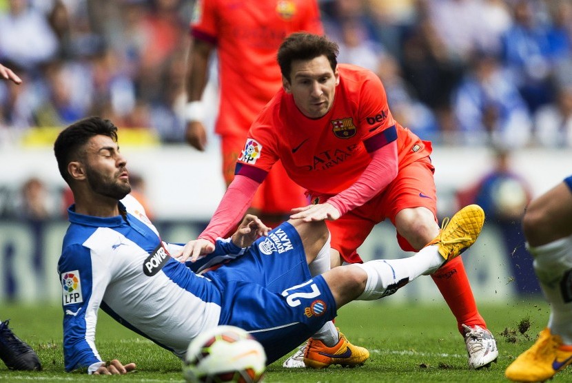  FC Barcelona's Argentinian striker Lionel Messi (R) in action against Espanyol's defender Ruben Duarte (L) during the Spanish Primera Division soccer match between RCD Espanyol and FC Barcelona in Barcelona, northeastern Spain, 25 April 2015. 