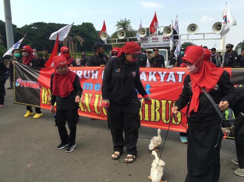 Federasi Serikat Pekerja Aneka Indonesia (FSPASI) membawa tiga bebek untuk menujukkan rasa penolakannya terhadap RUU Omnibus Law, Jakarta Pusat, Rabu (14/10).