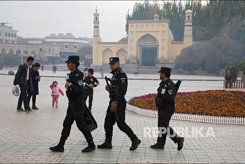 FILE - In this Nov. 4, 2017, file photo, Uighur security personnel patrol near the Id Kah Mosque in Kashgar in western China