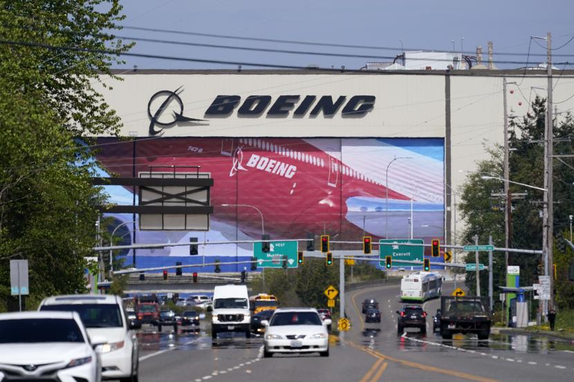 Lalu lintas di depan pabrik produksi Boeing Co., di mana gambar jet menghiasi pintu hanggar pada 23 April 2021, di Everett, Washington. Boeing berencana memangkas staf di departemen keuangan dan sumber daya manusia pada 2023. Pemangkasan itu akan berdampak pada kehilangan sekitar 2.000 pekerjaan.