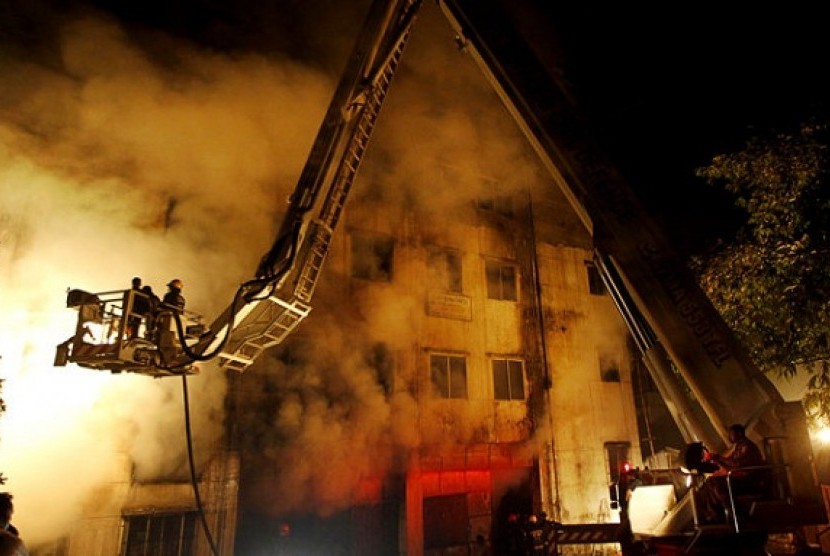 Firefighters battle a fire at a garment factory in the Savar neighborhood in Dhaka, Bangladesh, late Saturday, Nov. 24, 2012. At least 112 people were killed in a fire that raced through the multi-story garment factory just outside of Bangladesh's capital,