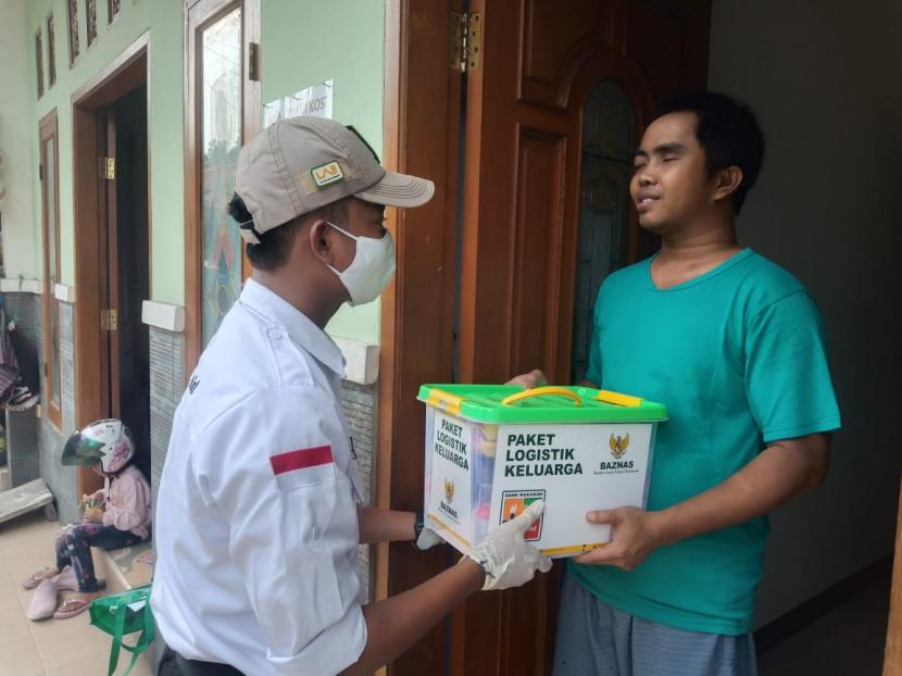 Firmansyah, salah seorang tukang pijat disabilitas menerima bantuan Paket Logistik Keluarga berisi sembako dari tim Layanan Aktif BAZNAS, di Bekasi.