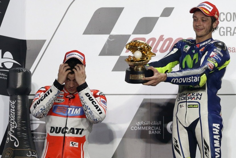 First-placed Yamaha MotoGP rider Valentino Rossi (R) of Italy celebrates on the podium next second-placed compatriot Ducati MotoGP rider Andrea Dovizioso after the Qatar MotoGP Grand Prix at the Losail International circuit in Doha March 29, 2015.