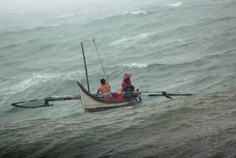 Fishermen works hard to control their small boat during the storm in Padang. (illustration)