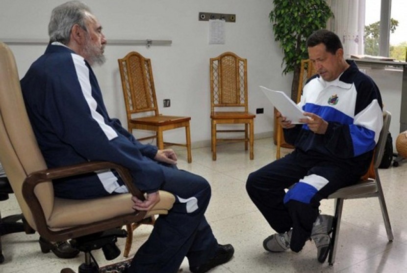 Former Cuban leader Fidel Castro (left) looks on as Venezuela's President Hugo Chavez reads a document in Havana in this July 3, 2011 file handout photo. 