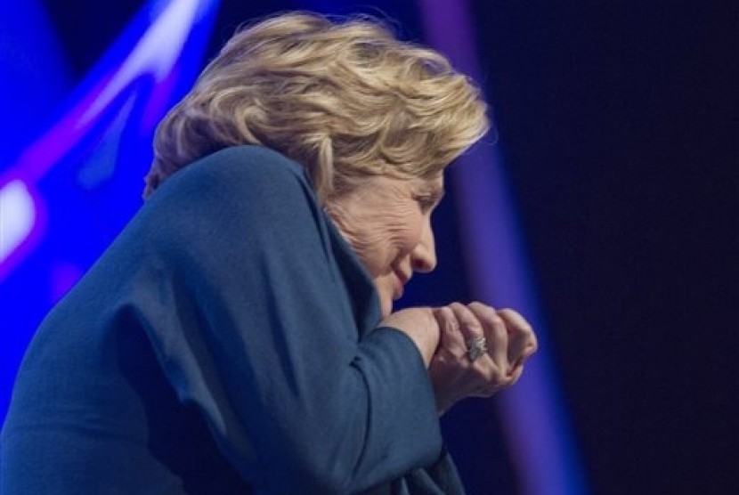 Former US Secretary of State Hillary Rodham Clinton ducks as an object is thrown on stage at the Mandalay Bay Convention Center, Thursday, April 10, 2014, in Las Vegas. 