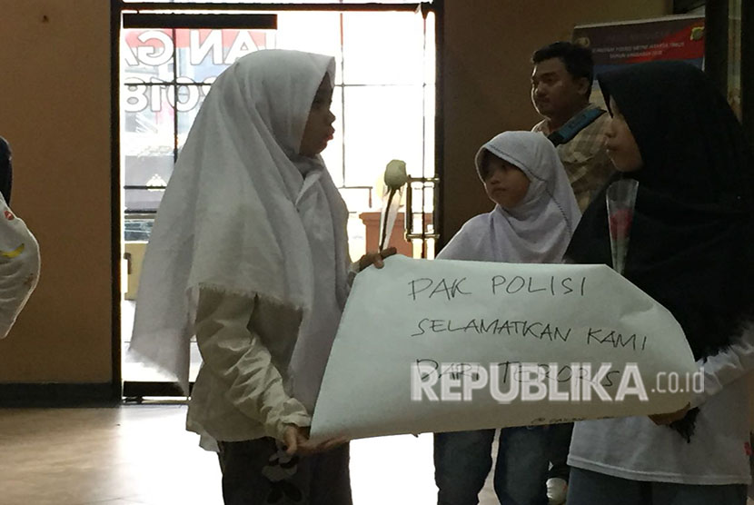 Forum Anak Cakung bersama perwakilan KPAI, berikan bunga kepada anggota polisi di Polres Metro Jakarta Timur, kepada Wakapolres Metro Jakarta Timur mereka meminta agar polisi melindungi anak-anak dari doktrin terorisme, Sabtu (19/5). 