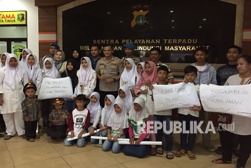 Forum Anak Cakung bersama perwakilan KPAI, berikan bunga kepada anggota polisi di Polres Metro Jakarta Timur, kepada Wakapolres Metro Jakarta Timur mereka meminta agar polisi melindungi anak-anak dari doktrin terorisme, Sabtu (19/5). 