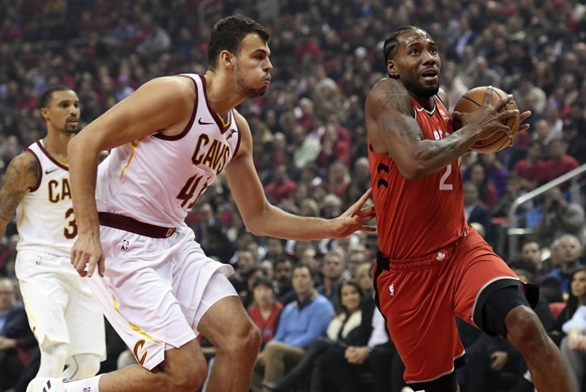Forward anyar Toronto Raptors, Kawhi Leonard (2) mencoba melewati center Cleveland Cavaliers Ante Zizic (41) dalam pertandingan NBA musim 2018/2019, Kamis (17/10) di Toronto
