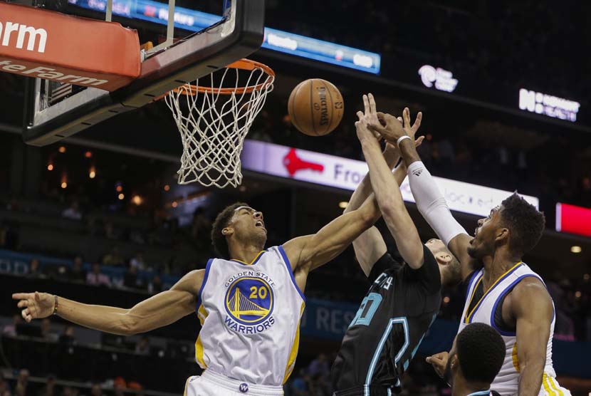 Forward Charlotte Hornets, Tyler Hansbrough (tengah), berebut bola dengan pemain Golden State Warriors dalam laga NBA pada Rabu (2/12). 