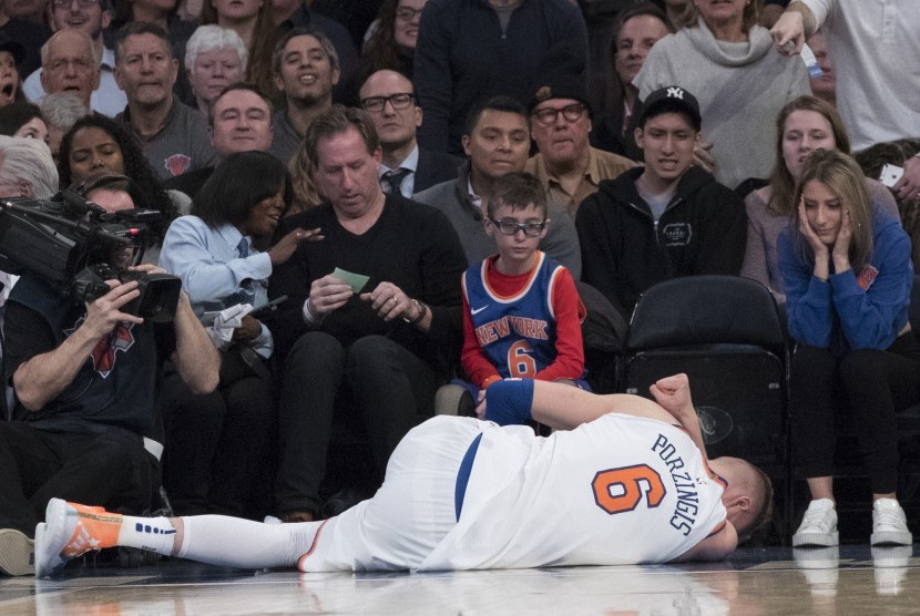 Forward New York Knicks, Kristaps Porzingis, terbaring di lapangan akibat mengalami cedera saat menghadapi Milwaukee Bucks di pertandingan basket NBA di Madison Square Garden, New York, Selasa (6/2) 