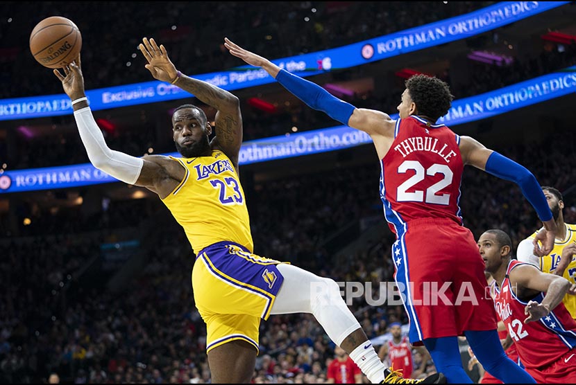 Forward Tim Los Angeles Lakers LeBron James (kiri) diadang pemain Philadelphia 76ers Matisse Thybulle (kanan) pada laga kedua tim di Philadelphia. Ahad (26/1) dini hari. 