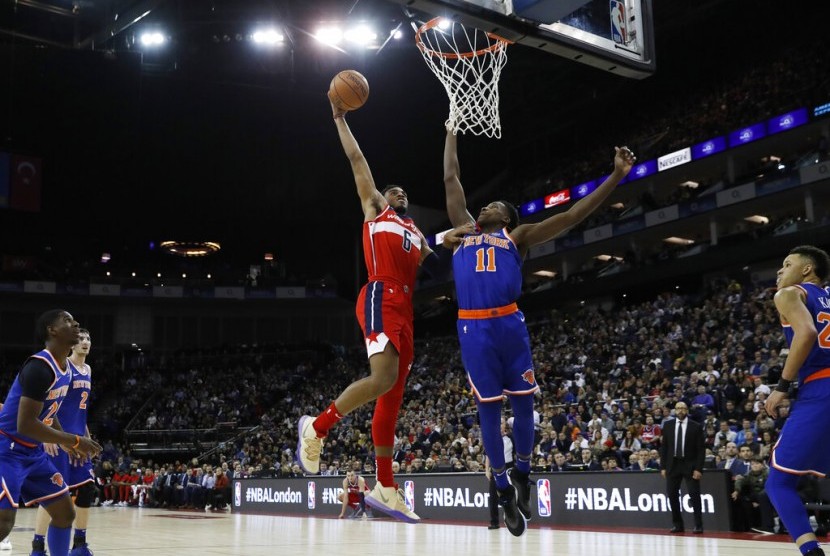 Forward Washington Wizards Troy Brown Jr. (kiri) mencoba mencetak angka dijaga guard New York Knicks Frank Ntilikina di O2 Arena, London.