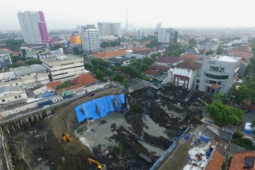 Foto aerial kondisi tanah ambles di Jalan Raya Gubeng, Surabaya, Jawa Timur, Rabu (19/12/2018). Jalan raya tersebut ambles sedalam sekitar 20 meter dengan lebar 30 meter pada Selasa (18/12/2018) malam diduga karena proyek pembangunan gedung di sekitar lokasi. 