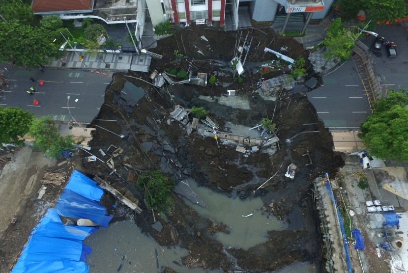 Foto aerial kondisi tanah ambles di Jalan Raya Gubeng, Surabaya, Jawa Timur, Rabu (19/12/2018). Jalan raya tersebut ambles sedalam sekitar 20 meter dengan lebar 30 meter pada Selasa (18/12/2018) malam diduga karena proyek pembangunan gedung di sekitar lokasi. 